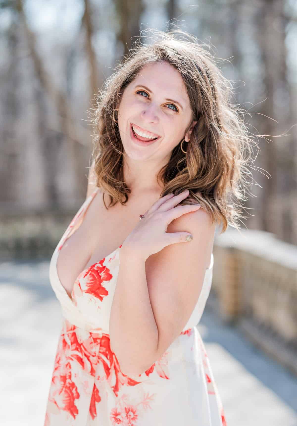 Cait Potter in a floral dress, smiling outdoors